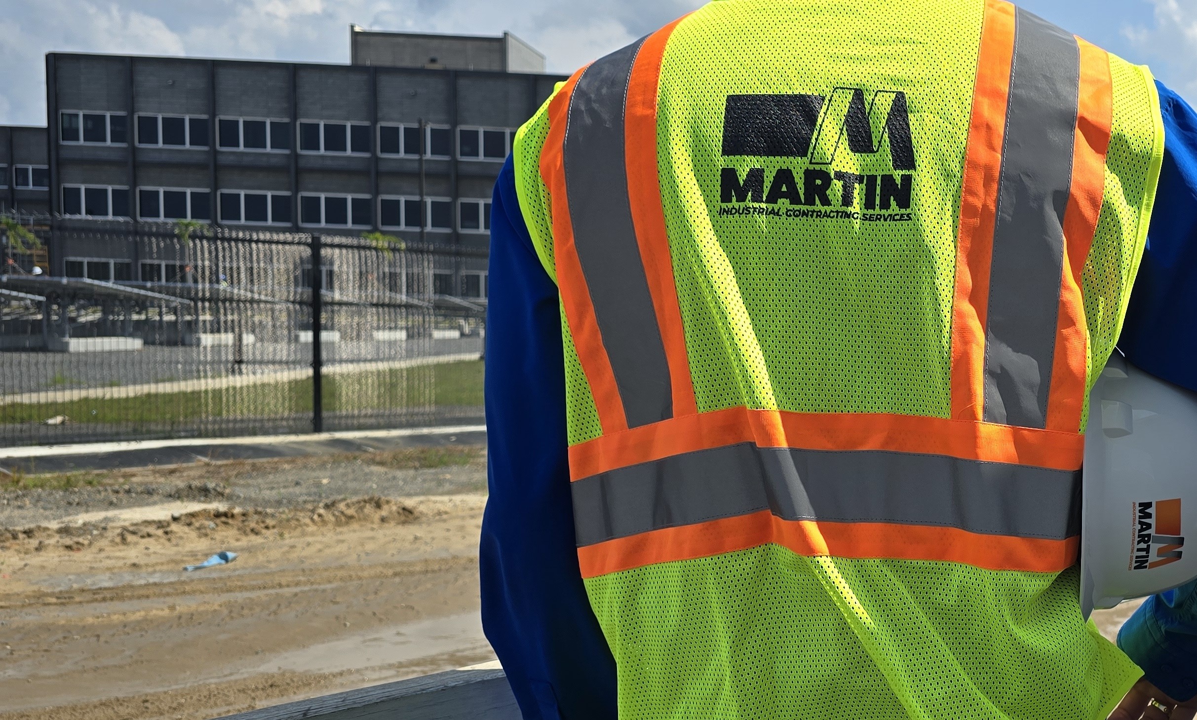 Membre de l'équipe Martin ICS en dossard de sécurité surplombant un chantier